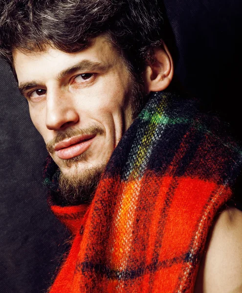 Portrait of handsome man warmed up in scarf, smiling closeup dark background