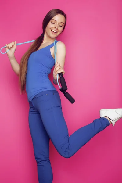 Young happy slim girl with skipping rope on pink background smiling sweety cute , good shape