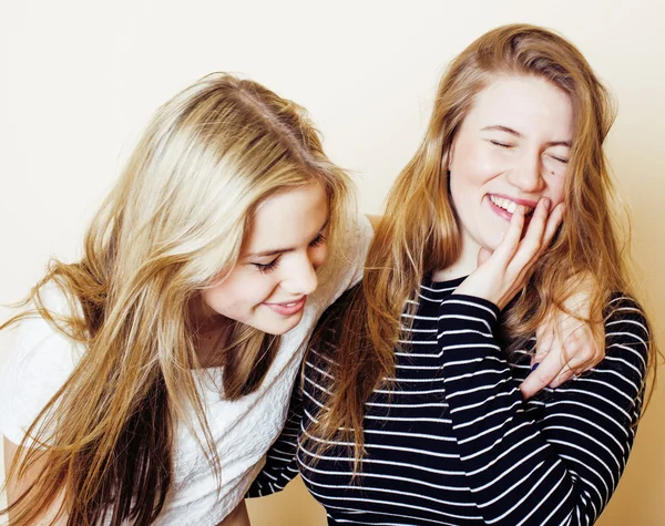 Two blond teenage girl fooling around messing hair