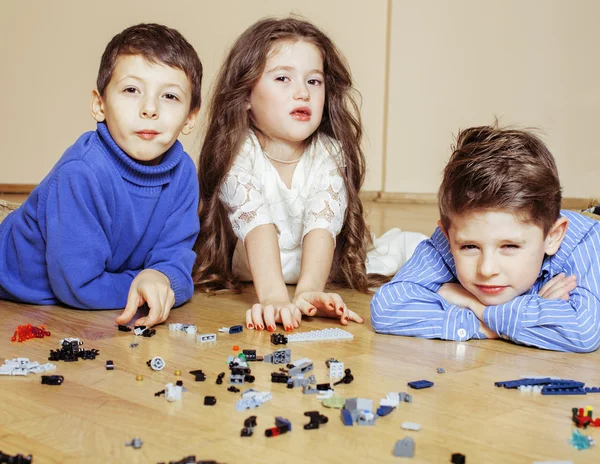 Funny cute children playing lego at home, boys and girl smiling, first education role
