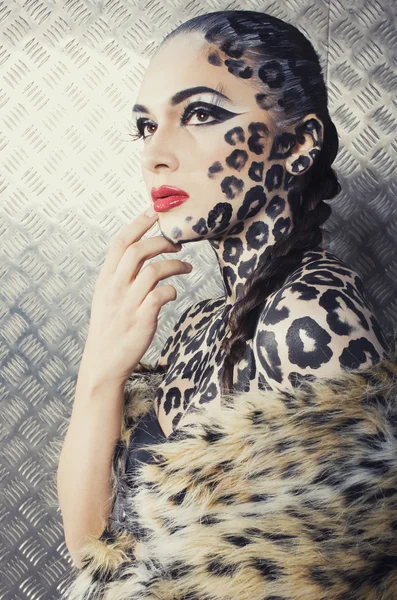 Young sexy woman with leopard make up all over body, cat bodyart closeup