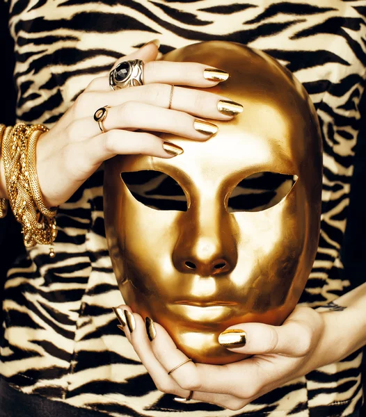 Hands holding golden carnival mask