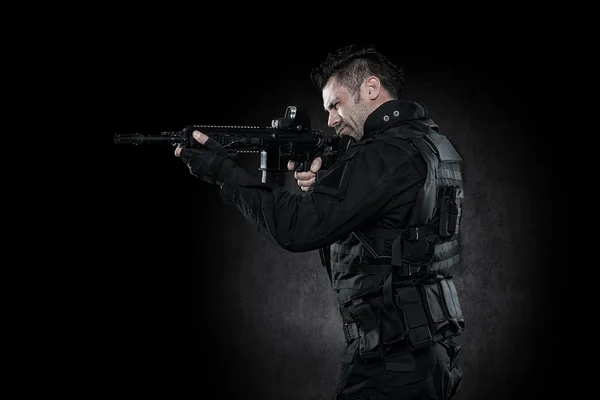 Spec ops police officer SWAT in black uniform studio