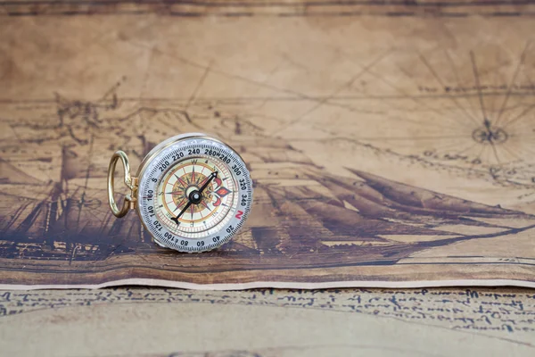 Vintage compass lies on an ancient map