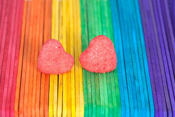 Heart candies coated with sugar sitting on color