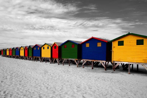 The row of wooden brightly colored huts on Sunrise Beach. Cape Town. South Africa.