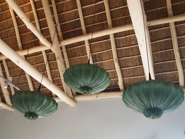Modern design wooden ceiling. Green chandeliers in the shape of