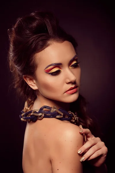 Fashion portrait of brown-eyes  woman. Gold jewelry. Orange yell