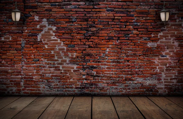 The lamp on the red brick walls and old wooden floors.