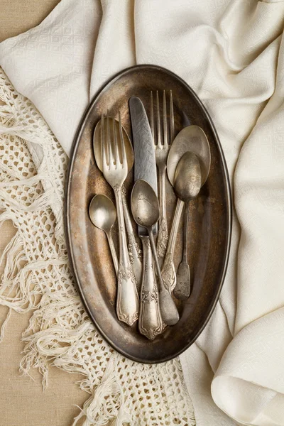 Vintage cutlery on a metal tray with a napkin