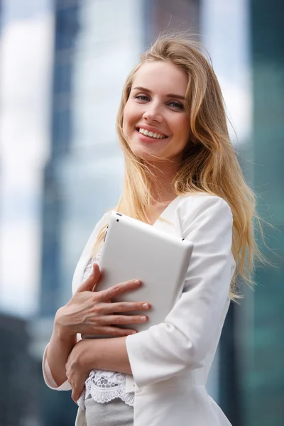 Beautiful woman with electronic tab in the street