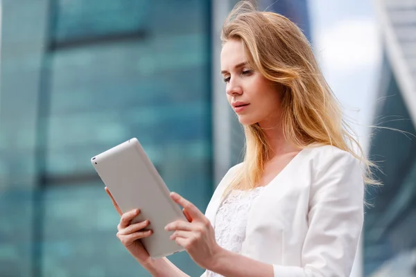 Beautiful woman with electronic tab in the street