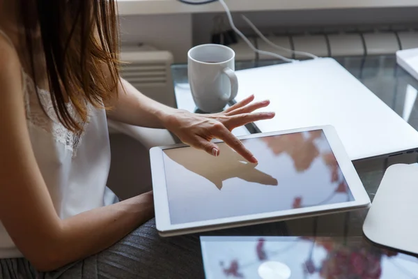 Young brunette girl touching screen of white modern laptop