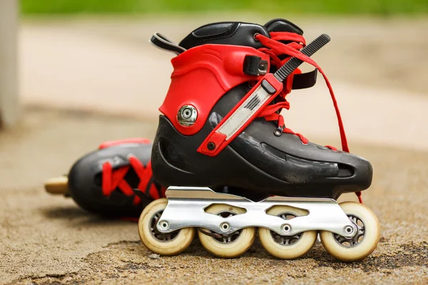 Red roller blades close-up on nature background