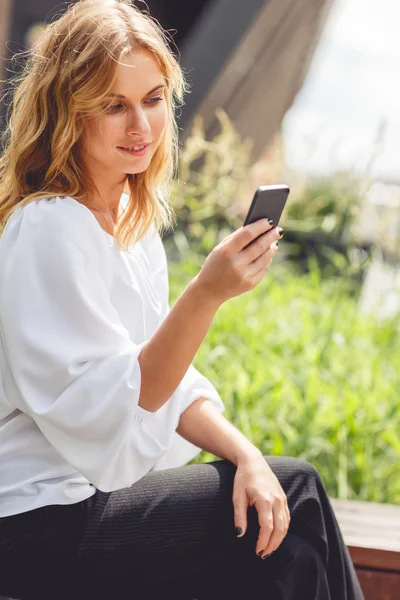 One young pretty blonde woman looking at phone