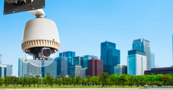 CCTV Camera or surveillance orperating with city building in bac