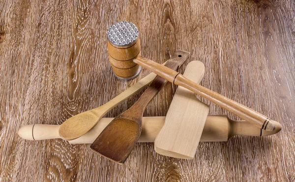Wooden kitchen tools on wooden background