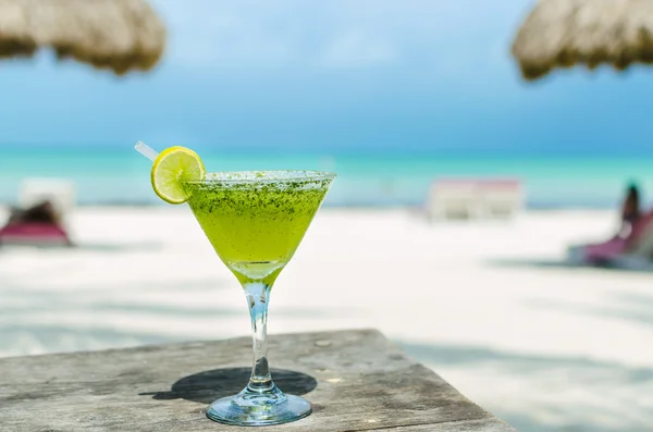 Fresh Margarita cocktail on a table at tropical white sandy beach in the Caribbean sea