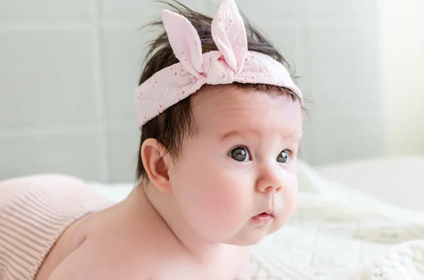 Cute sweet little newborn baby girl looking with curiosity side-face