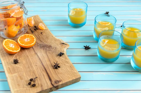 Homemade tangerine jelly in glasses over wooden rustic turquoise background