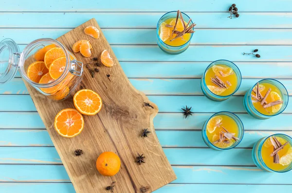 Homemade tangerine jelly in glasses over wooden rustic turquoise background