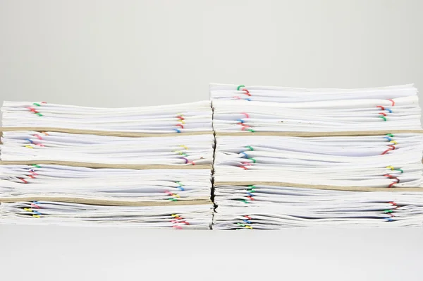 Pile of overload paperwork and envelope on white background