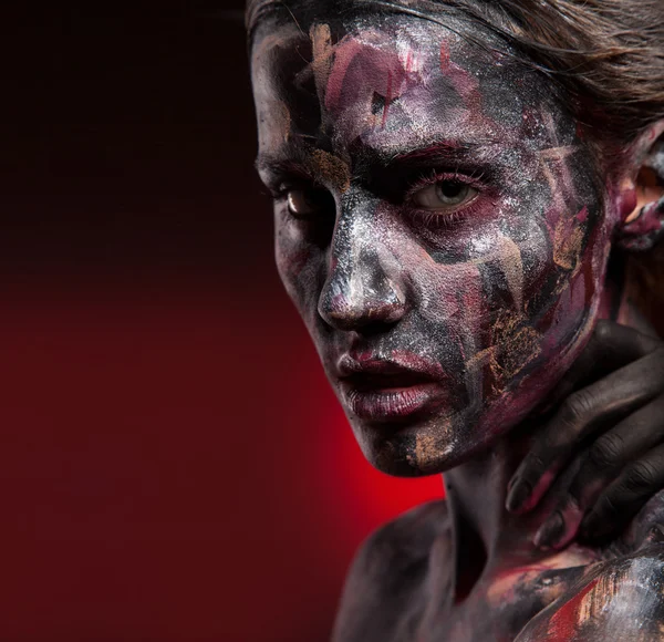 Woman painted with face art and body art