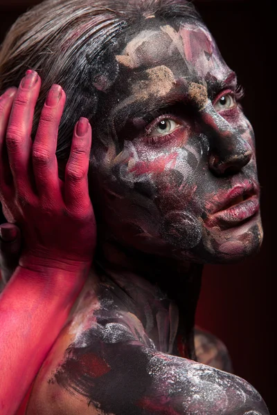 Woman painted with face art and body art