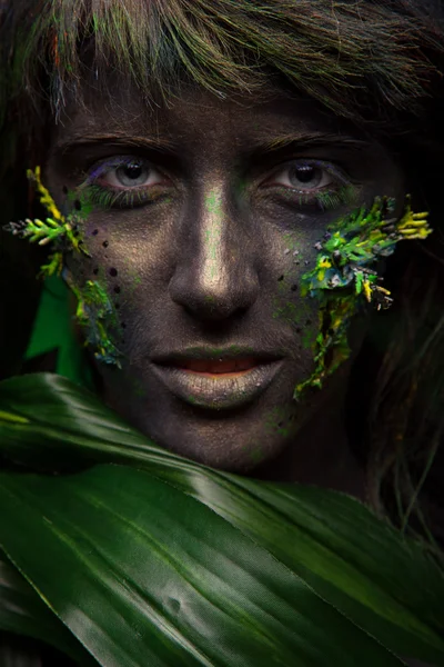 Woman with black face and green face art