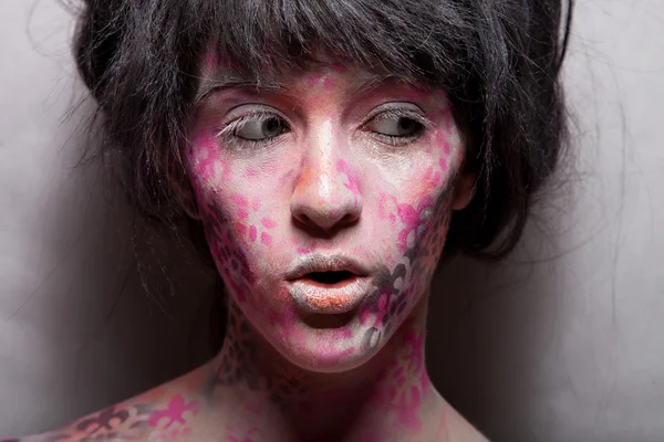 Woman with pink body art and face art