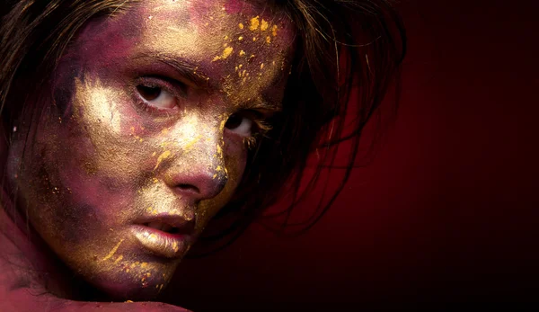 Girl with gold paint on face