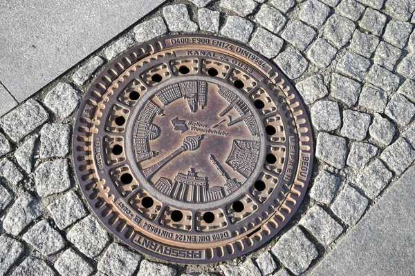 Intricate waterboard manhole cover in a street in Berlin
