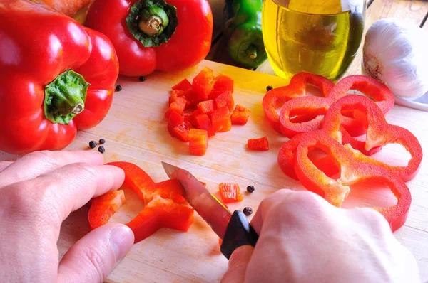 Chef cutting a red pepper on a cutting board