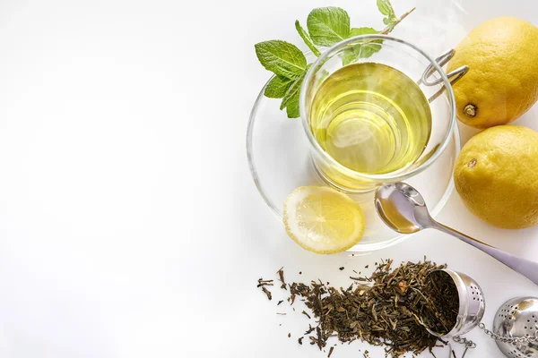 Green tea with mint lemon and metal strainer top view