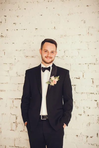 Portrait of a smiling groom in the room.