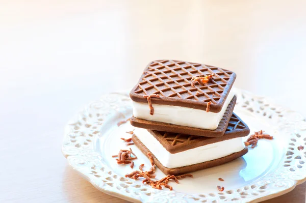 Two brown and white ice-cream sandwiches. Chocolate with vanilla