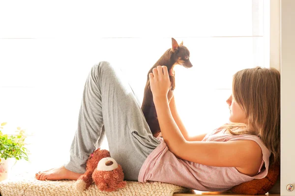 Good morning! Young girl in pyjamas holding her lovely dog