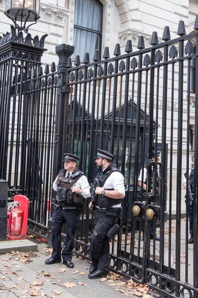 LONDON, UK - OCTOBER,10, 2014: Police officers in front of the gate of Downing street, residence of the prime minister, in London United Kingdom