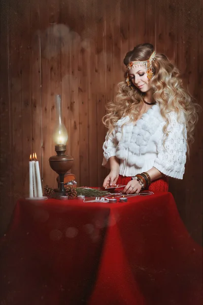 Young beautiful girl stands near a fortune teller desk with a la