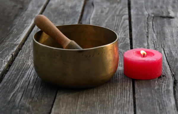 Singing Bowl and burning red candle