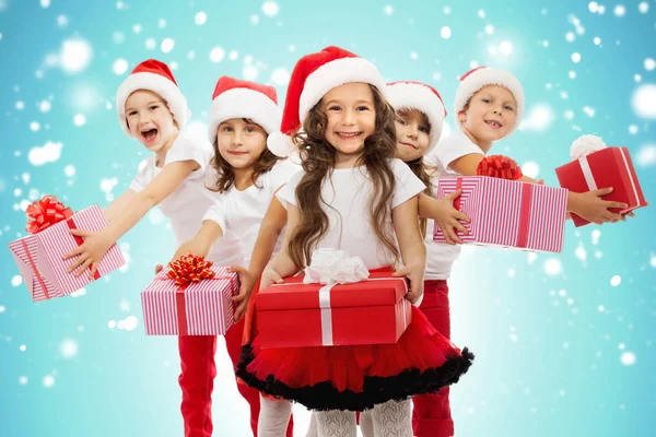 Group of happy kids in Christmas hat with presents