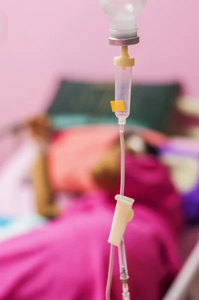 Infusion bottle with patient in bed in hospital