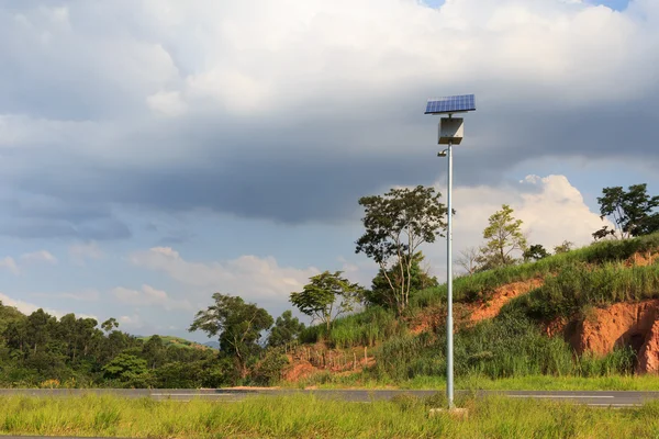 Electric pole with solar panel on road in countryside