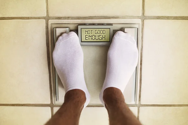 Man\'s feet on bathroom scale. Diet concept