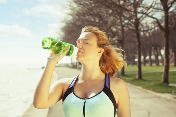 Fitness runner woman drinking water or energy drink