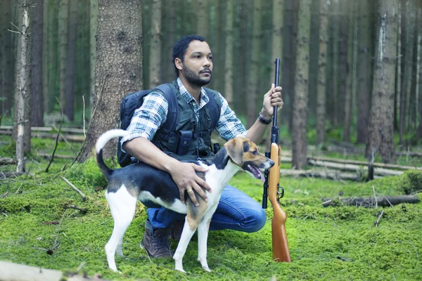 Interracial hunter in the forest with hunting dog