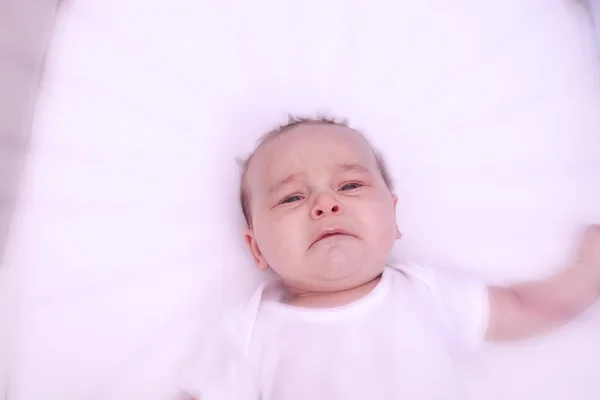 Scared crying baby, alone, in his crib