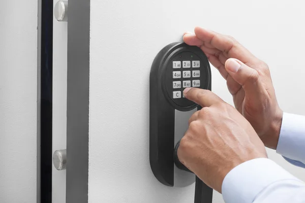 Interracial businessman hand entering security system code