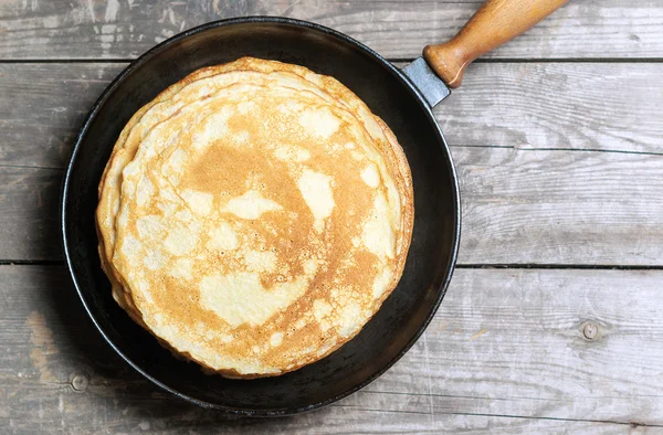 Stack of pancakes on a cast-iron frying pan. Top view