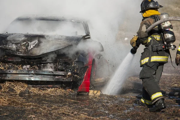 Firemen training on a burning car at the New Baltimore Fire Station